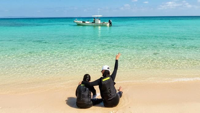 沖縄・浜比嘉島の無人島で貸切シュノーケルツアーを楽しむカップル